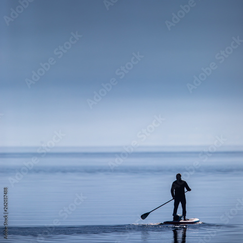 Man on a stand up padlle board on a lake