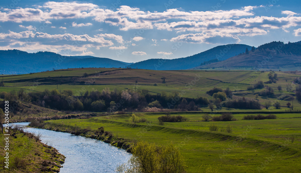 Olt river in Transylvania, Romania, blue mountains at early spring, landscape image.