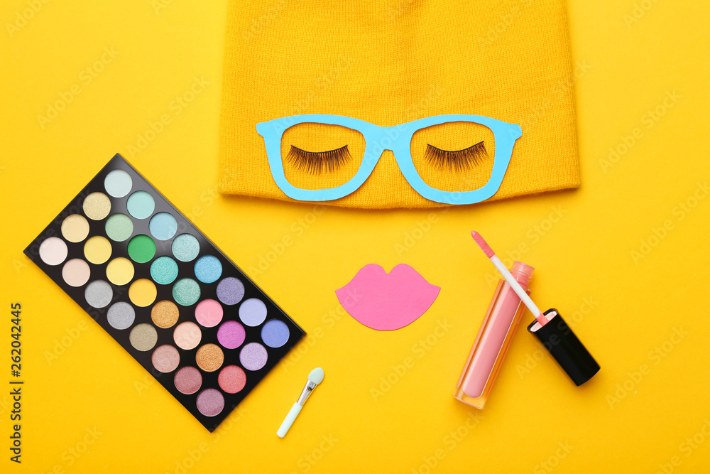 Eyelashes with paper lips, glasses and makeup cosmetics on yellow background. Minimalism concept Eyelashes with paper lips, glasses and makeup cosmetics on yellow background. Minimalism concept