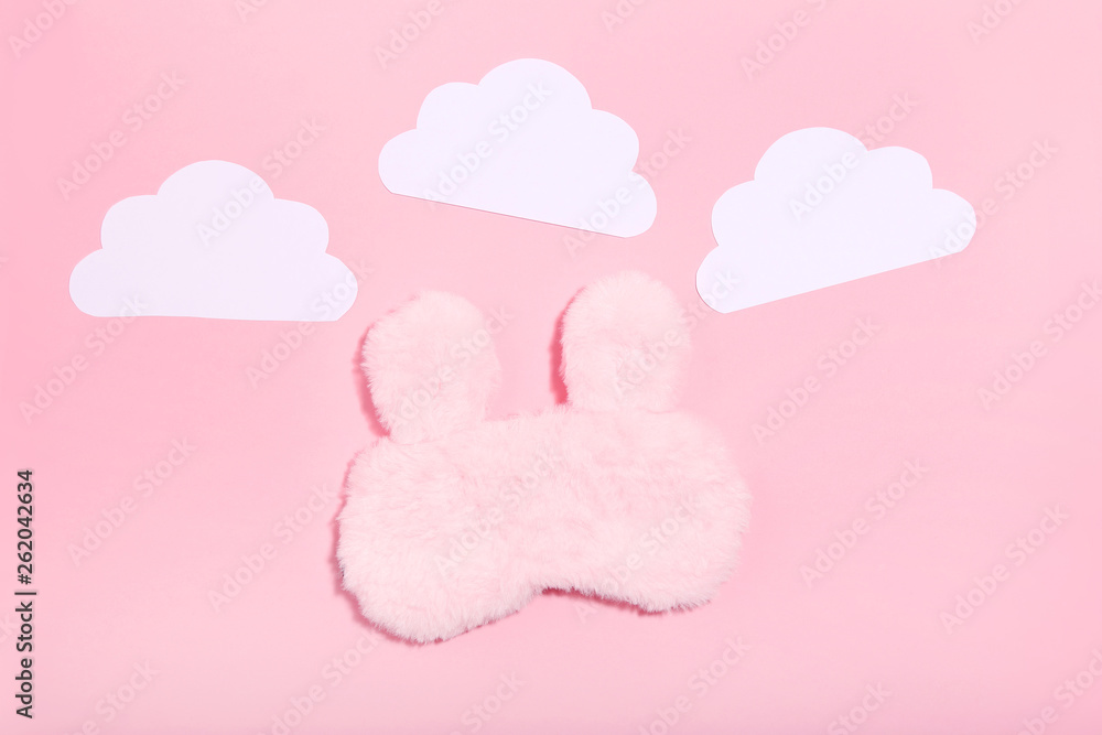 Sleeping mask with paper clouds on pink background. Minimalism concept