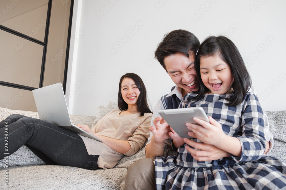 Happy Asian family spending time together at home playing game, tablet for education Happy Asian family spending time together at home playing game, tablet for education