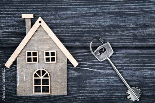 Silver key with house symbol on black wooden table