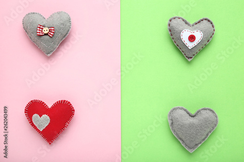 Grey and red fabric hearts on colorful background