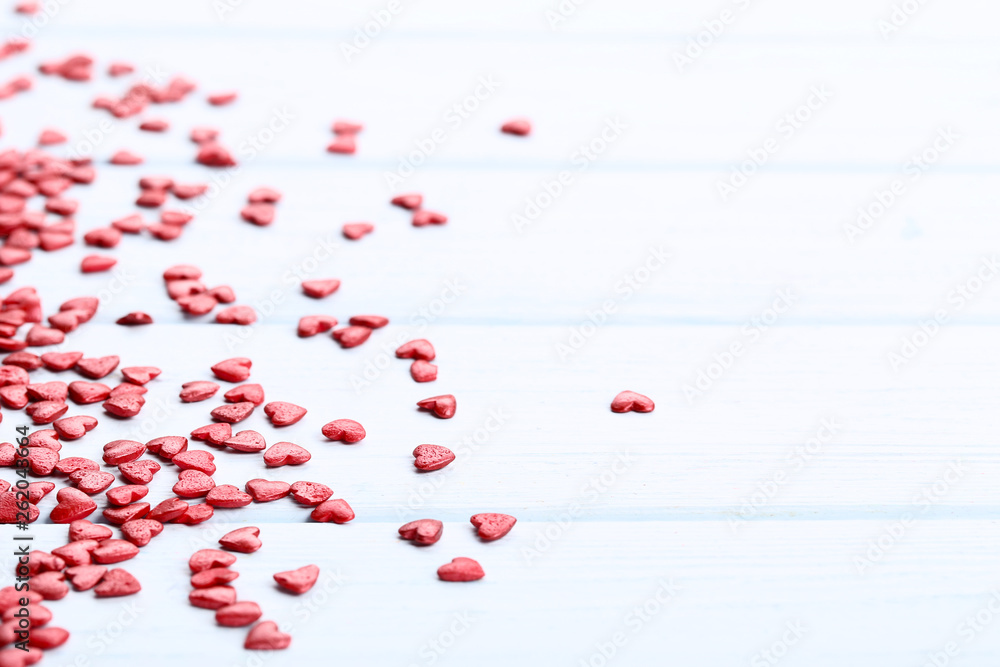 Red heart shaped sprinkles on wooden table Red heart shaped sprinkles on wooden table