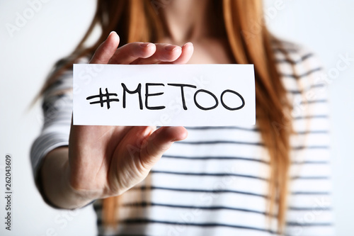 Foto Woman holding paper with text Me Too on grey background