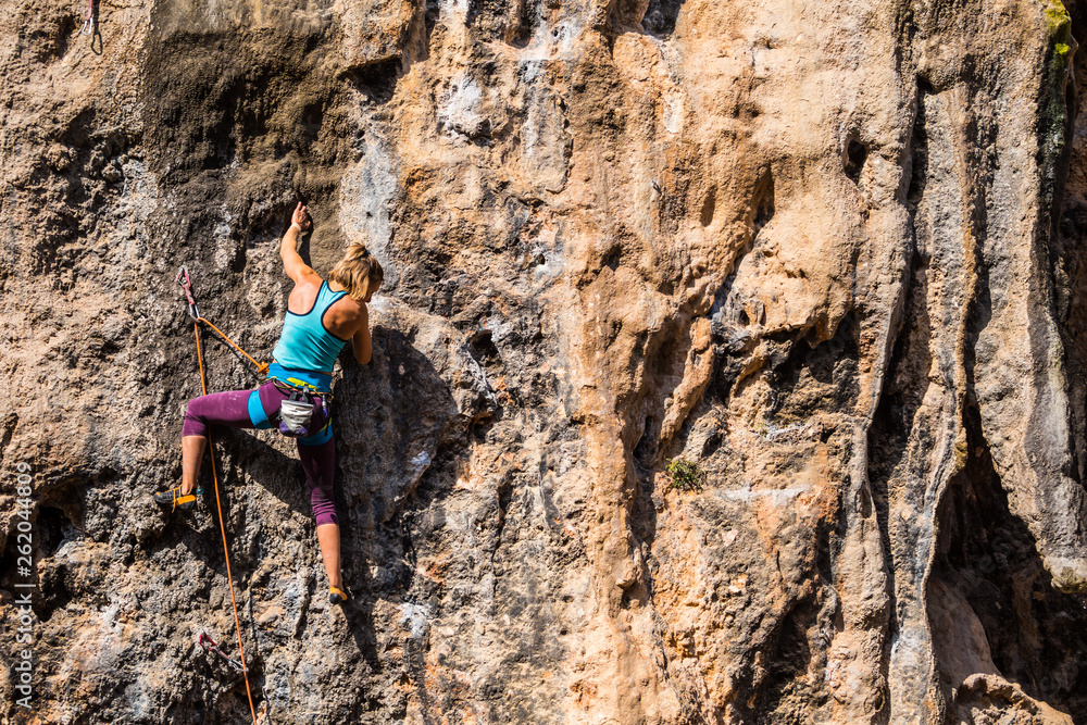A girl climbs a rock.