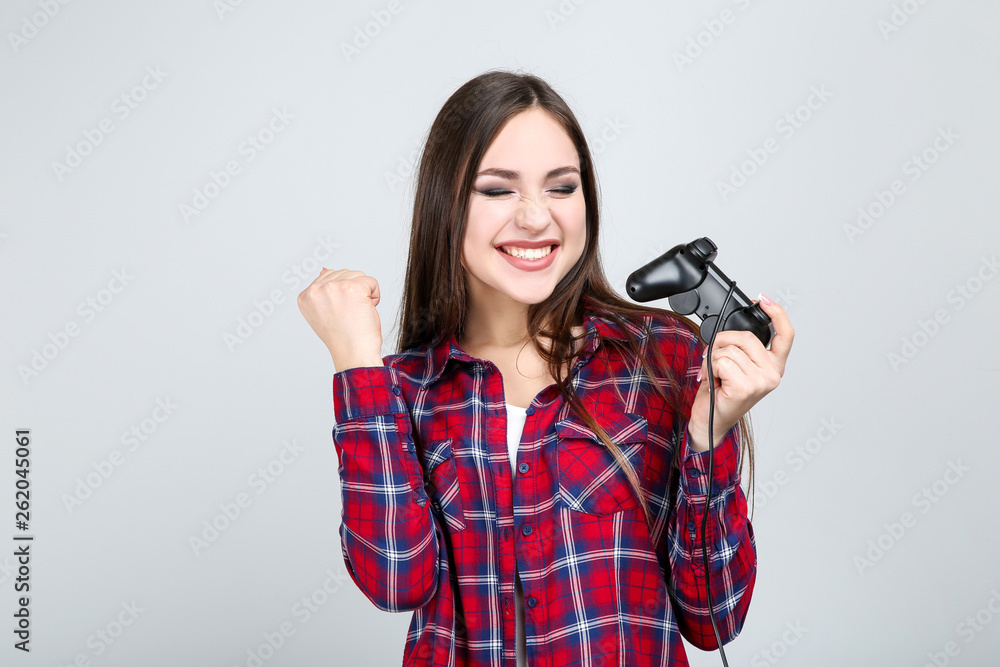 Beautiful girl with joystick on grey background Beautiful girl with joystick on grey background