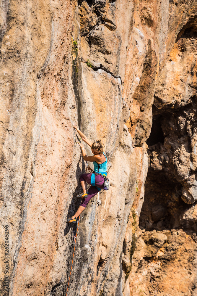 A girl climbs a rock.