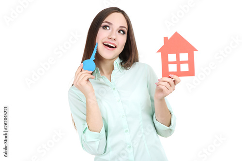 Young woman showing paper house and keys on white background