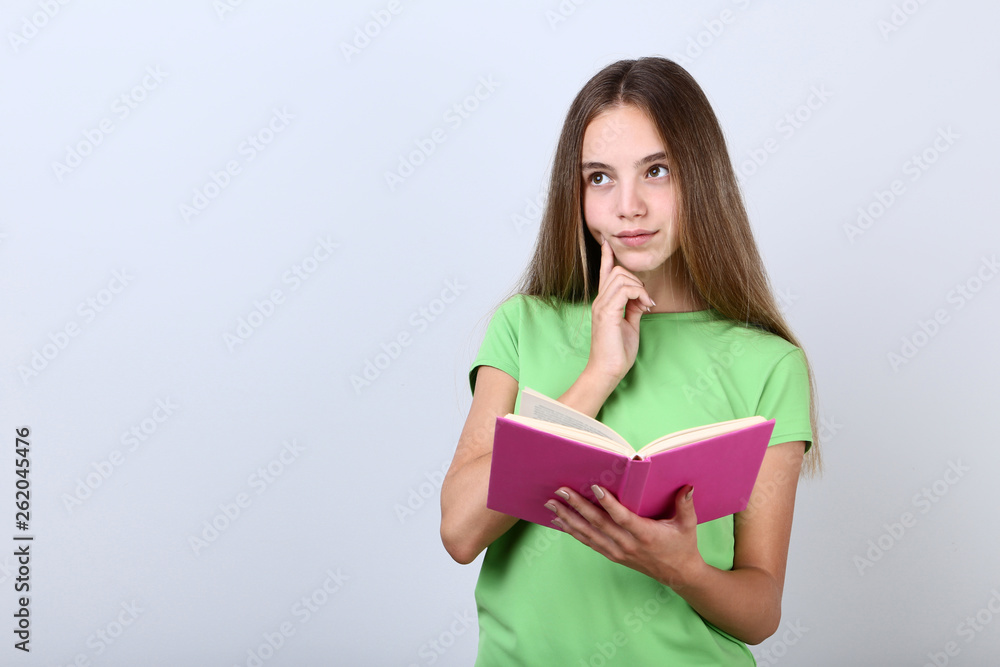 Young girl with book on grey background Young girl with book on grey background