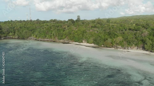 Aerial: Flying over tropical beach turquoise water coral reef , Tomia island Wakatobi National Park Indonesia Maldives Polynesia white sand beach. Native cinelike D-log color profile photo