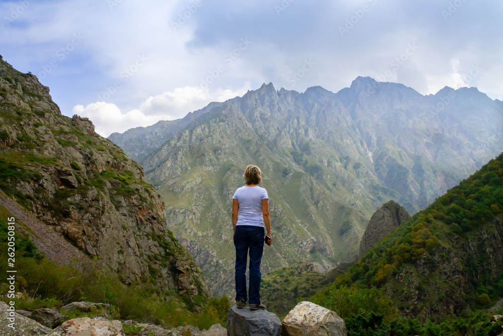 A young woman in the mountains of Stepantsminda, looking into the distance. Georgia.
