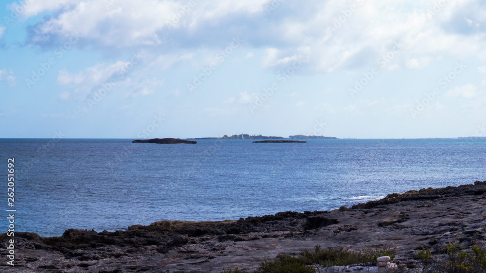 Rocky beach with distant islands in the bright sunlight of the Bahamas.