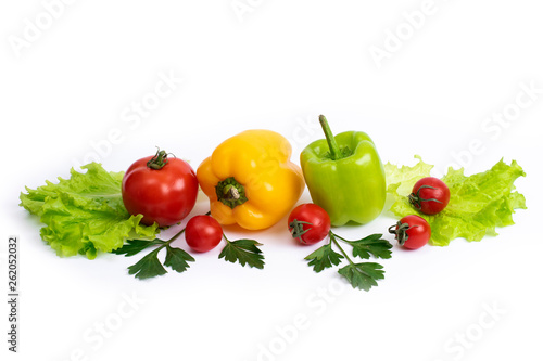 Cherry tomatoes with greens and sweet peppers on a white background. Green pepper and yellow with tomatoes and herbs on a white background..