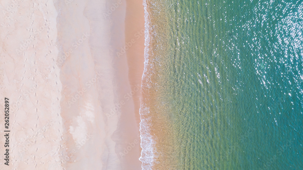 Fototapeta premium Aerial view of Beach with shade emerald blue water and wave foam on tropical sea