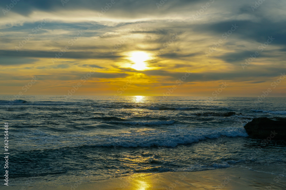 Beautiful colorful sunset over the sea, clouded sky on twilight time and reflection on the sea. in La Jolla, San Diego, California, USA Beautiful colorful sunset over the sea, clouded sky on twilight time and reflection on the sea. in La Jolla, San Diego, California, USA