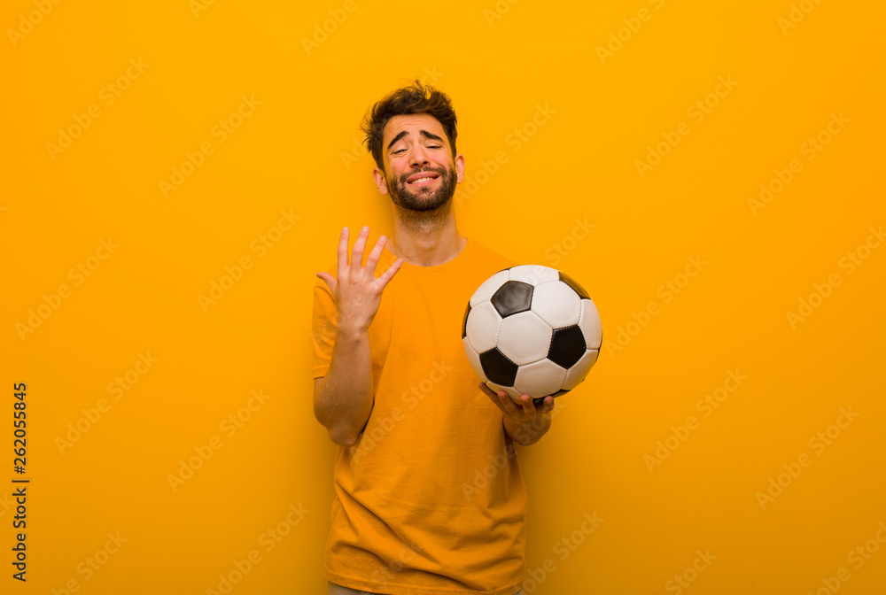 Young soccer player man very scared and afraid