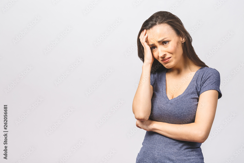 Studio shot of displeased European woman frowns face in discontent, cries from pain, wears casual, models over white studio wall. People, depression, negative feelings. Studio shot of displeased European woman frowns face in discontent, cries from pain, wears casual, models over white studio wall. People, depression, negative feelings.