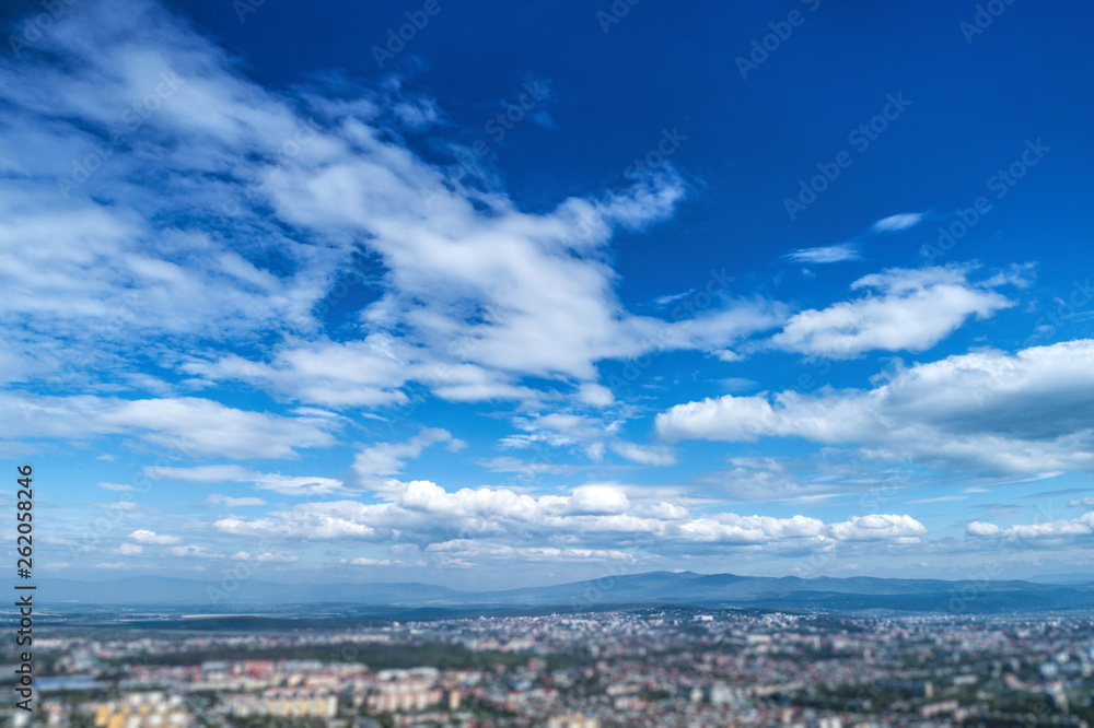 Blue sky with white clouds and horizon line.