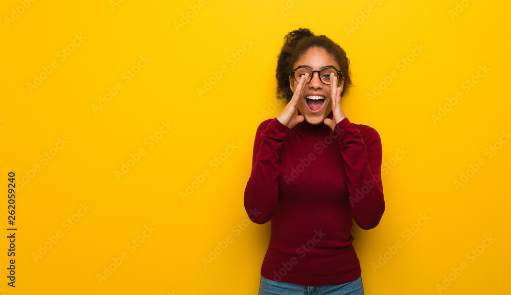 Young black african american girl with blue eyes shouting something happy to the front