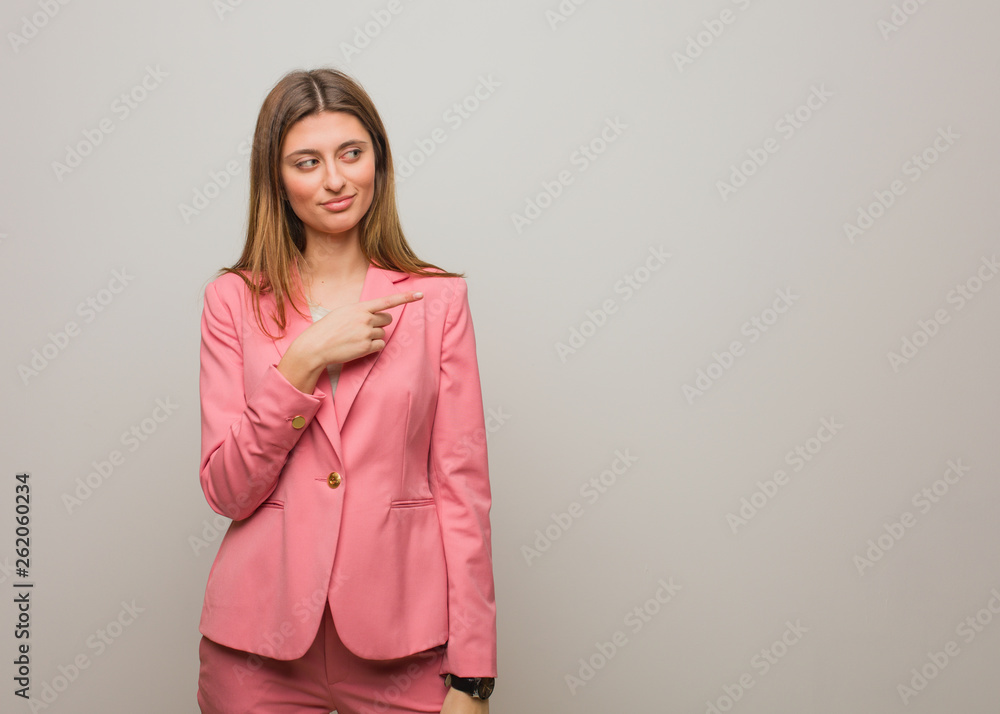 Young business russian girl smiling and pointing to the side Young business russian girl smiling and pointing to the side