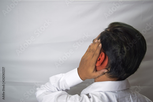 man having ear pain touching his painful inflamed ear isolated on white background