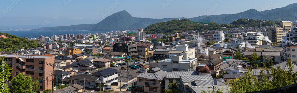 Fototapeta premium Panorama of Skyline of Beppu City and Bay, with hot steam and onsen. Beppu, Oita, Japan, Asia.
