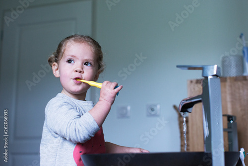 Little girl brushing her teeth photo