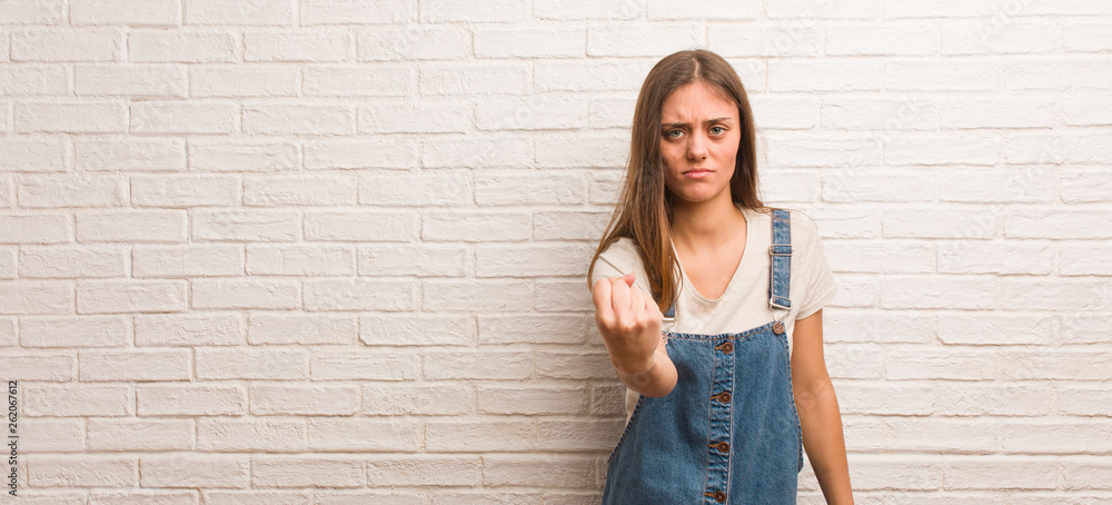 Young hipster woman showing fist to front, angry expression Young hipster woman showing fist to front, angry expression