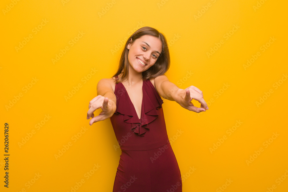 Young elegant woman wearing a dress cheerful and smiling pointing to front Young elegant woman wearing a dress cheerful and smiling pointing to front