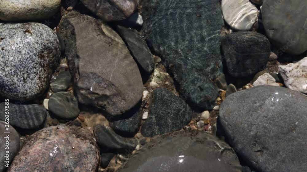 close-up of rocky beach. Water washes stones