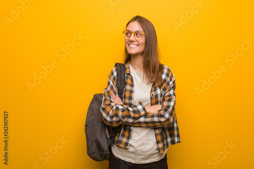 Young student woman smiling confident and crossing arms, looking up © Asier
