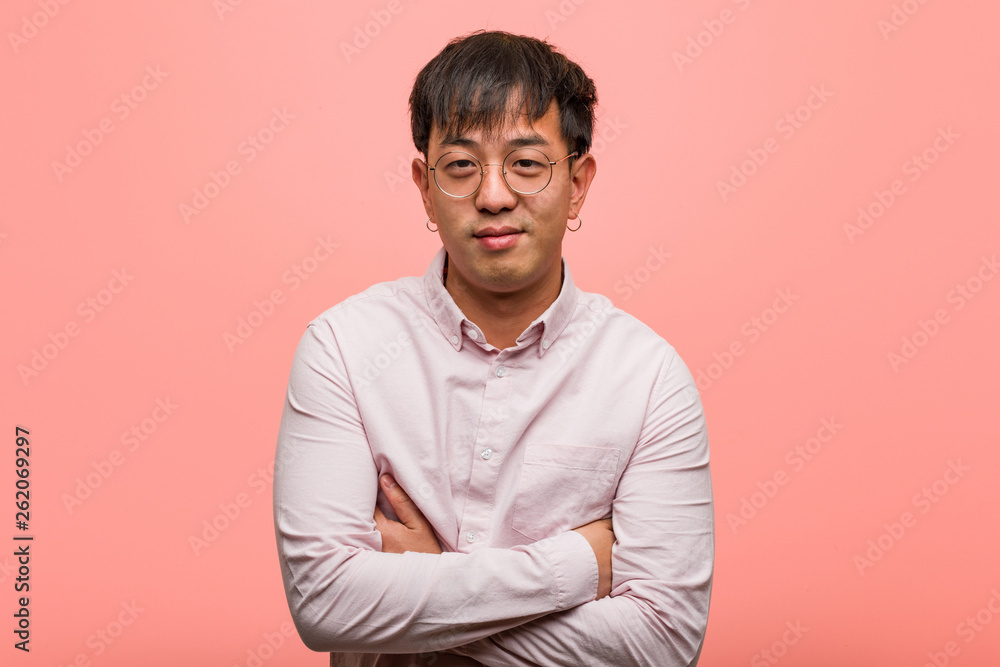Young chinese man crossing arms, smiling and relaxed Young chinese man crossing arms, smiling and relaxed
