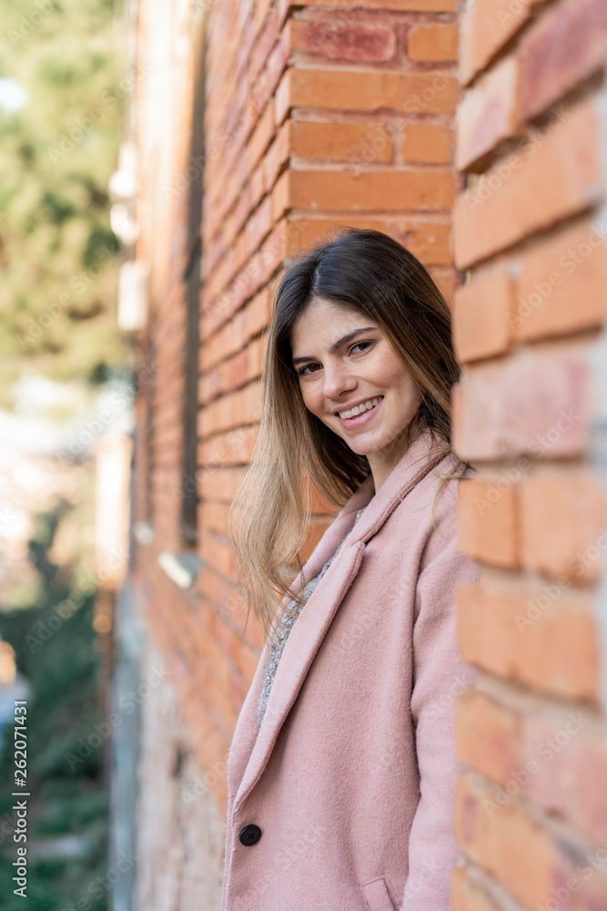Portrait of a happy young woman at a brick building Portrait of a happy young woman at a brick building