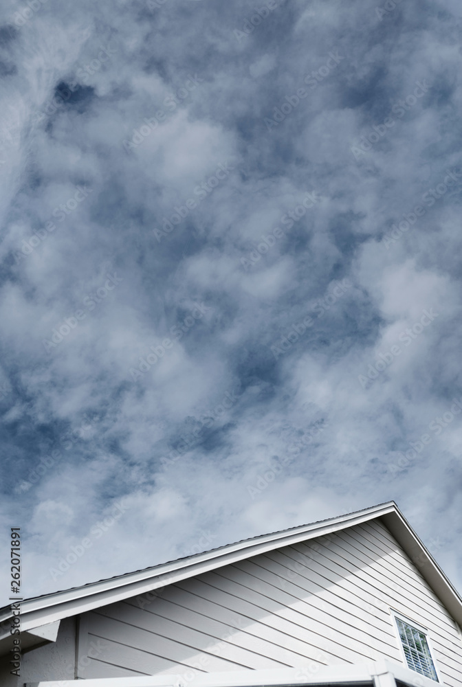 Cloudy sky over roof top of residential house Cloudy sky over roof top of residential house