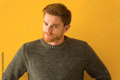 Young redhead man face closeup scolding someone very angry