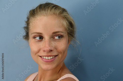 Portrait of smiling young blond woman looking sideways photo