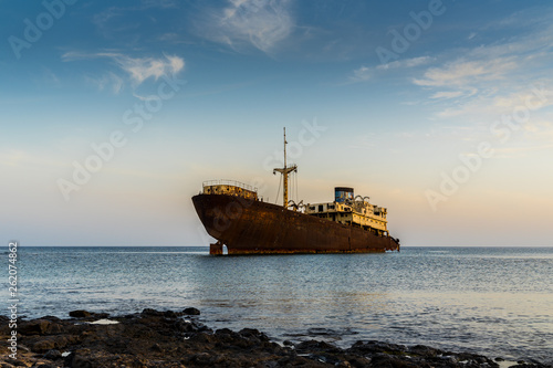 Spain, Lanzarote, Magic rusty red old wreck of temple hall ship stranded at coast of arrecife