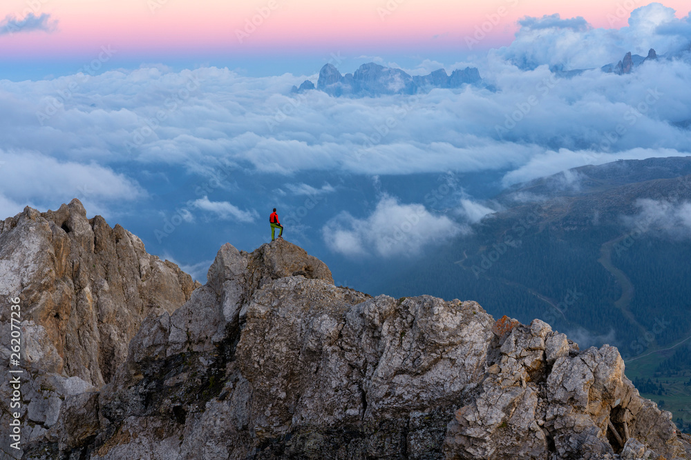 Italy, Veneto, Dolomites, Alta Via Bepi Zac, mountaineer standing on Pale di San Martino mountain at sunset