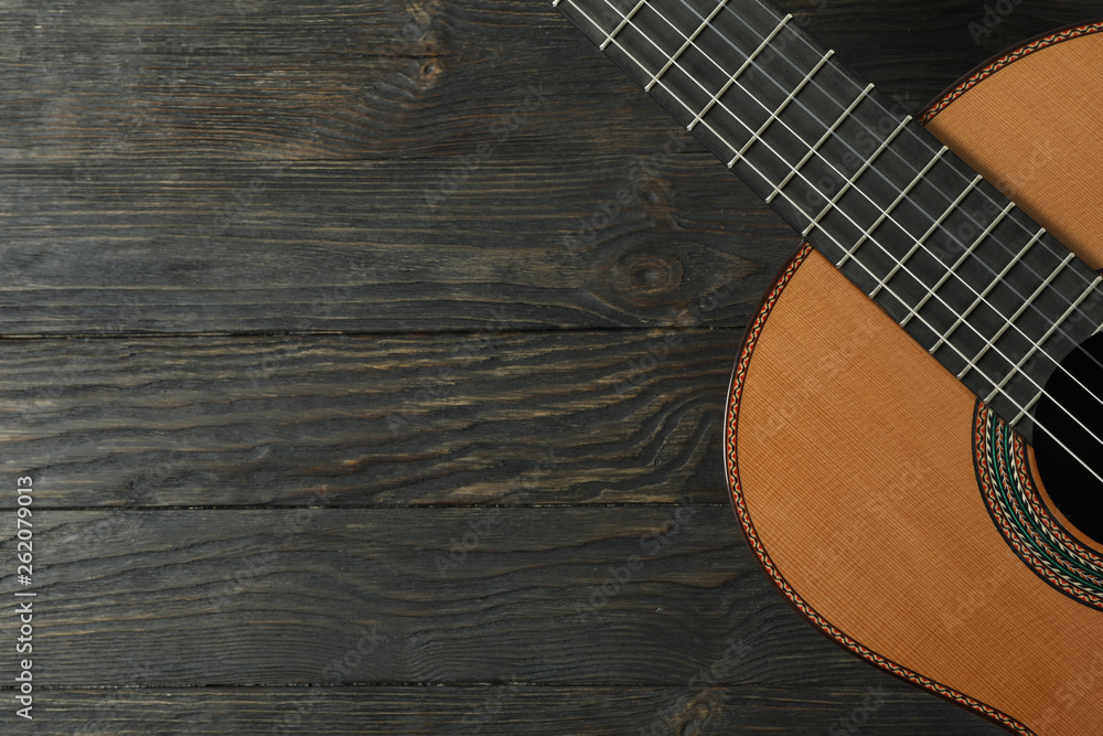 Beautiful six - string classic guitar on wooden background, space for text Beautiful six - string classic guitar on wooden background, space for text