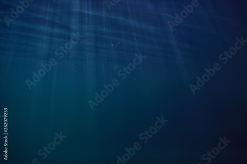 ocean water blue background underwater rays sun / abstract blue background nature water