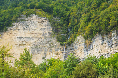 The Kinchkha waterfall in the canyon of the river Okatse. Rest in Georgia. High waterfall in the Imereti region. Rocky ledges of the mountain with green trees. photo