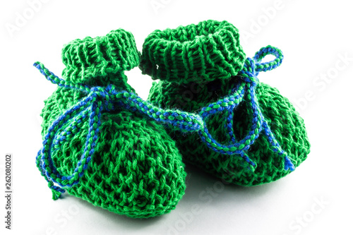 green knitted baby shoes on white background