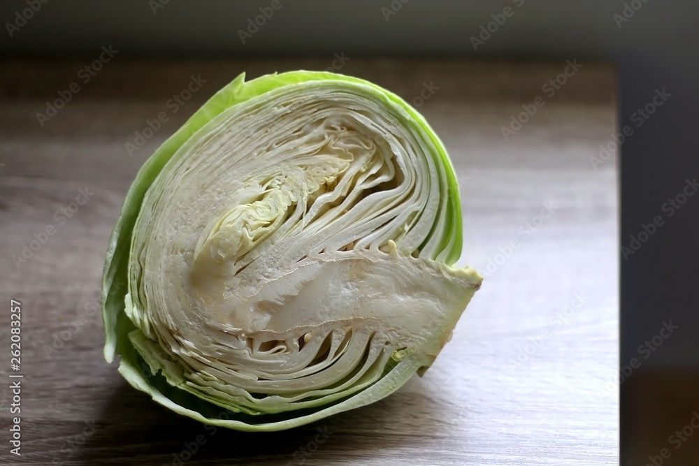 Obraz premium Half of cabbage on a wooden table. Selective focus.