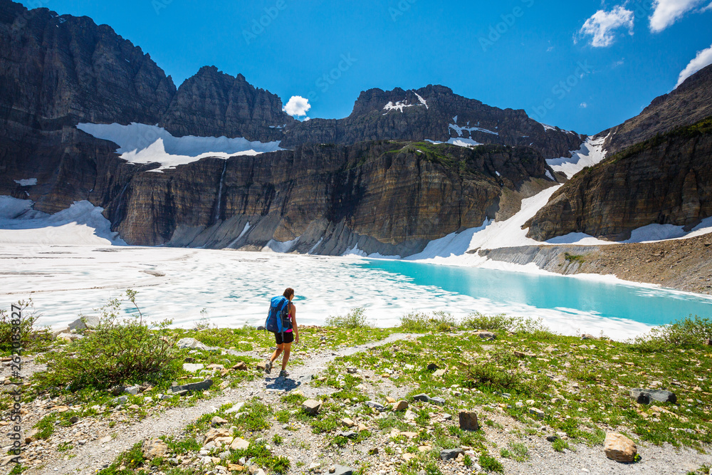 Woman hiking past Upper Grinell Lake along Grinell Glacier, USA Woman hiking past Upper Grinell Lake along Grinell Glacier, USA