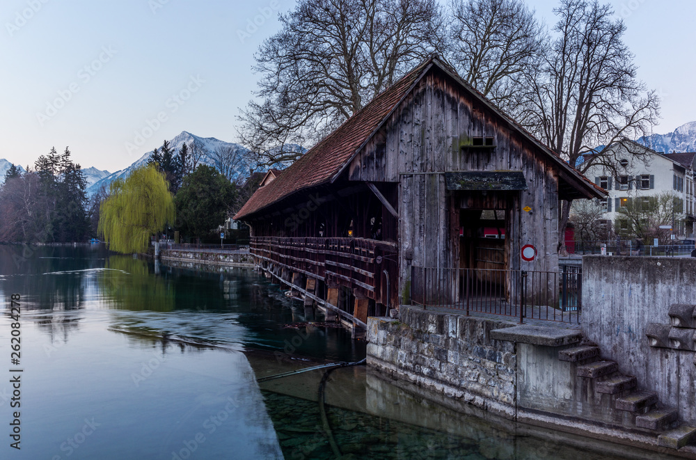 A wooden bridge crossing the river Aare in Thun with the Jungfrau and Eiger mountains in the background early in the morning - 3