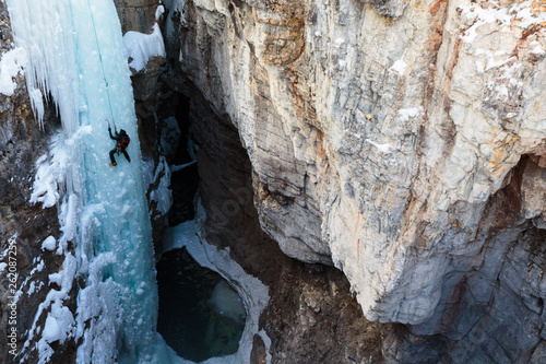 Alpine climbing legend John Roskelley climbing the 45 meter/148-foot Tokumm Pole above the Tokumm Creek in the scenic Marble Canyon, BC in Kootenay National Park near Banff, Alberta. The rugged, narrow slot canyon is a popular summer destination with the turquoise waters of Tokumm Creek flowing at the bottom. But in the winter it is a hotspot for ice climbing, snowshoeing, and nordic skiing.
