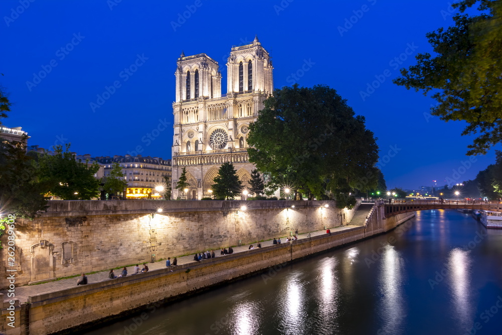 Notre-Dame de Paris Cathedral and Cite island embankment at night, France