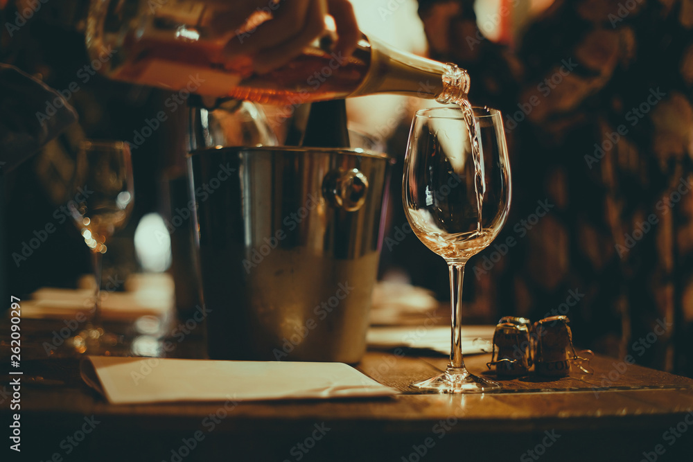  wine tasting: on a wooden table there are silver buckets for cooling wines with bottles of champagne, there are brochures and glasses in which champagne is poured.