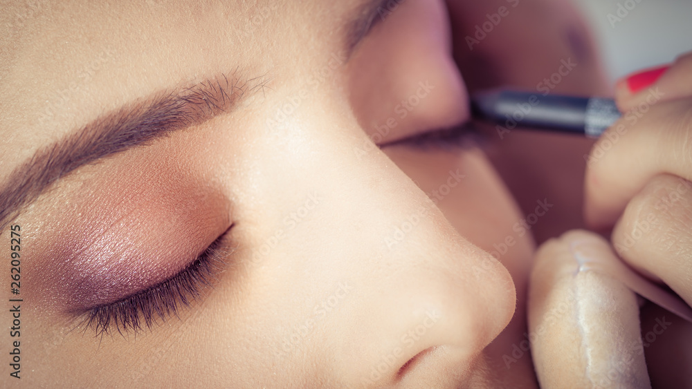 Professional artist is making beauty makeup to young girl Professional artist is making beauty makeup to young girl